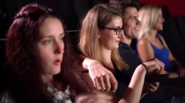 Sinemada film izleyen gençler, fotoğrafçılar.