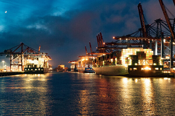 Port of Hamburg with its huge container terminals by night - HAMBURG, GERMANY - MAY 10, 2021