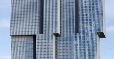 ROTTERDAM, NETHERLANDS - 13 Eylül 2025 - De Rotterdam Binası bulutlu gökyüzü, Rotterdam, Hollanda 'daki cam cephesini yansıtıyor. ROTTERDAM, NETHERLANDS - 13 Eylül 2025 -