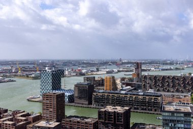 ROTTERDAM, NETHERLANDS - 13 Eylül 2025 - Rotterdam şehir manzarası modern binaları, limanları ve sanayi bölgesini bulutlu gökyüzü altında gösteriyor. ROTTERDAM, NETHERLANDS - 13 Eylül 2025 -