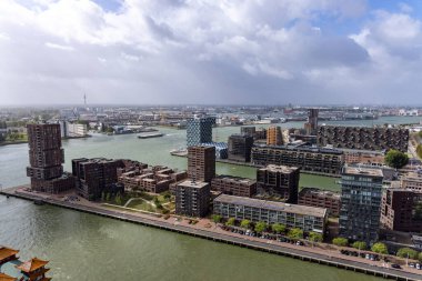 ROTTERDAM, NETHERLANDS - 13 Eylül 2025 - Rotterdam şehir manzarası modern mimari ve bulutlu bir gökyüzü altında Nieuwe Maas nehri. ROTTERDAM, NETHERLANDS - 13 Eylül 2025 -