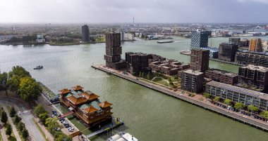 ROTTERDAM, NETHERLANDS - 13 Eylül 2025 Modern mimari ve yüzen bir Çin restoranının yer aldığı Rotterdam şehir manzarası. ROTTERDAM, NETHERLANDS - 13 Eylül 2025 -
