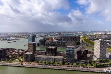 ROTTERDAM, NETHERLANDS - 13 Eylül 2025 - Rotterdam şehir manzarası modern mimari, liman ve bulutlu gökyüzü altında Nieuwe Maas nehri. ROTTERDAM, NETHERLANDS - 13 Eylül 2025 -