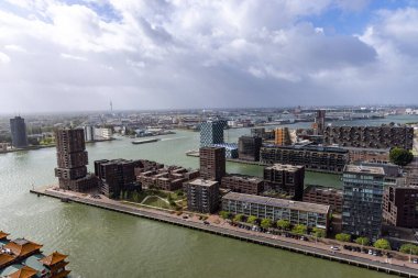 ROTTERDAM, NETHERLANDS - 13 Eylül 2025 - Modern binalar, Nieuwe Maas nehri ve bulutlu gökyüzü içeren Rotterdam şehir manzarası. ROTTERDAM, NETHERLANDS - 13 Eylül 2025 -