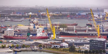 ROTTERDAM, NETHERLANDS 13 Eylül 2025 bulutlu bir günde Rotterdam limanının siluetine hükmeden turnalar. ROTTERDAM, NETHERLANDS - 13 Eylül 2025 -