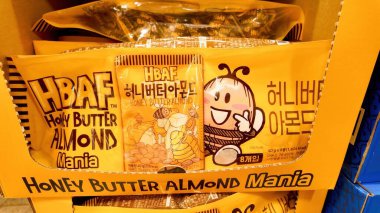 SEOUL, Güney Kore - 11 Ekim 2025 - HBAF 'ın bal yağı badem paketleri perakende satış ortamında gülümseyen bir arı karakteri sergiliyor