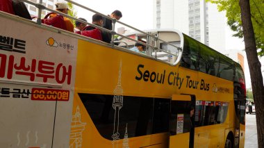 SEOUL, Güney Kore - 11 Ekim 2025 - Seul 'de üst güvertede turistlerin sürdüğü çift katlı sarı otobüs