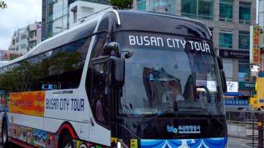 BUSAN, Güney Kore - 9 Ekim 2025 Busan Şehir Tur otobüsü bir şehir caddesinde turizm ve Güney Kore 'de seyahat teklifinde bulundu.