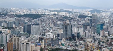 Seul, Güney Kore, uzak dağlara uzanan binaların ve şehir merkezinin bulunduğu şehir manzarası