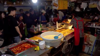 SEOUL, Güney Kore - 11 Ekim 2025 - Güney Kore, Seul 'deki Gwangjang Market standında Bindaetteok' u kızartan sokak satıcısı