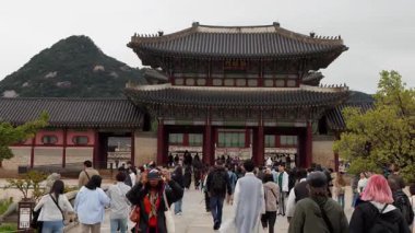 SEOUL, Güney Kore - 11 Ekim 2025 Bulutlu bir günde Güney Kore 'nin tarihi bir simgesi olan Gyeongbokgung Sarayı' na giren turistler