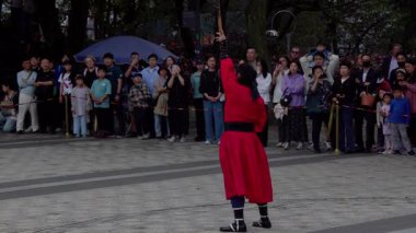 SEOUL, Güney Kore - 11 Ekim 2025 - Seul 'de hayranları için dövüş sanatları gösterisi yapan geleneksel kostümlü bir sanatçı