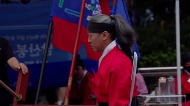 SEOUL, Güney Kore - 11 Ekim 2025 - Geleneksel kırmızı Hanbok üniformalı adam gardiyanın törensel değişimini gerçekleştiriyor