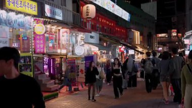 SEOUL, Güney Kore - 11 Ekim 2025 Hongdae, Seul, Güney Kore 'de insanlar kalabalık bir cadde boyunca yürüyorlar.