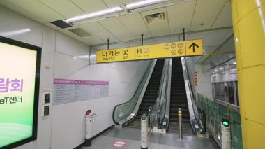 SEOUL, Güney Kore - 11 Ekim 2025 Modern Seul metro istasyonunda çıkış tabelalarına doğru ilerleyen yürüyen yürüyen merdivenler