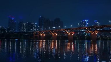 SEOUL, Güney Kore - 11 Ekim 2025 - Han Nehri Aydınlatılmış köprüyü ve şehir binalarını yansıtıyor