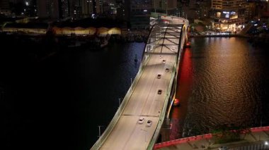 BUSAN, Güney Kore - 10 EKİM 2025 - Yeongdodaegyo köprüsünde gece vakti şehrin ışıklarıyla giden arabaların havadan görünüşü