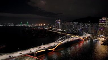 BUSAN, GÜNEY KOREA - 10 EKİM 2025 - Busan 'ın geceleri gökyüzü, köprüler ve liman ışıkları suya yansıyor