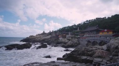 BUSAN, Güney Kore - 10 Ekim 2025 - Haedong Yonggungsa Tapınağı engebeli sahilde dalgalar kayalara çarpıyor