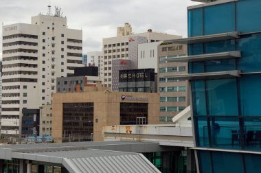 BUSAN, Güney Kore - 9 Ekim 2025 - Busan şehir manzarası çeşitli mimari ve binaları bulutlu bir gökyüzü altında sunar