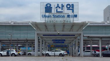 ULSAN, Güney Kore - 10 Ekim 2025 - Ulsan İstasyonu girişi park halindeki taksileri ve bulutlu gökyüzünün altındaki modern bir binayı gösteriyor