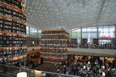 SEOUL, Güney Kore - 11 Ekim 2025 - Starfield Coex Mall Kütüphanesi 'ni keşfeden insanlar yüksek kitaplıkları ve avlu tavanı ile
