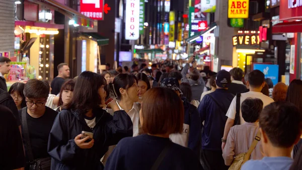SEOUL, Güney Kore - 11 Ekim 2025 - Seul 'deki Myeong dong alışveriş sokağında neon ışıklarıyla yürüyen bir kalabalık