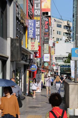 BUSAN, Güney Kore - 9 Ekim 2025 - Kalabalık Busan kentsel sokak sahnesi insanların renkli tabelaların önünden geçişlerini gösteriyor