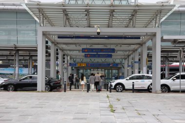 ULSAN, GÜNEY KOREA - 10 EKİM 2025 - Tren istasyonunun girişine doğru bavullarıyla yürüyen gezginler,