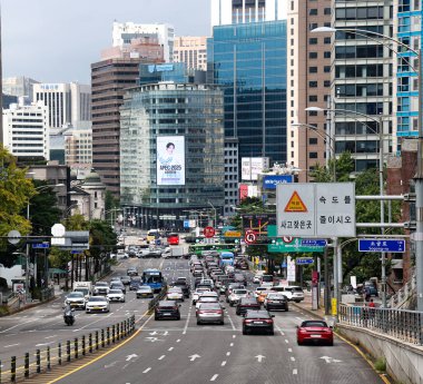 SEOUL, Güney Kore - 11 Ekim 2025 - Güney Kore 'de birçok araba, otobüs ve yüksek binaları olan işlek şehir caddesi