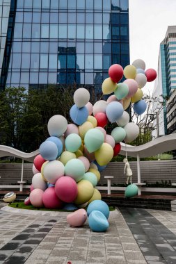 SEOUL, Güney Kore - 11 Ekim 2025 - Çocuk heykelciğiyle renkli balon kurulumu