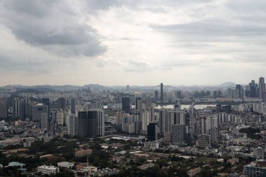 SEOUL, Güney Kore - 11 Ekim 2025 - Seul metropolitan bölgesi yüksek binaları ve dağları bulutlu bir gökyüzü altında