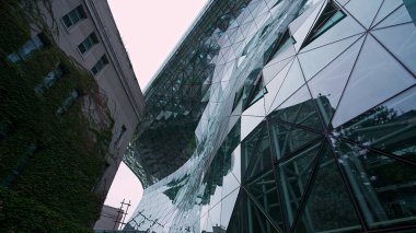 SEOUL, Güney Kore - 11 Ekim 2025 - Seul Belediye Binası çarpıcı bir modern cam cephe ve sarmaşıkla kaplı eski bir bina duvarı