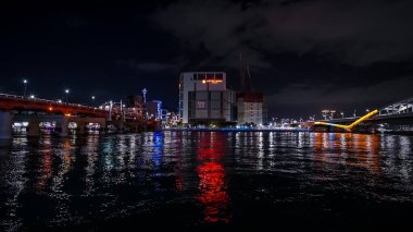 BUSAN, Güney Kore - 10 Ekim 2025 Busan şehir ışıkları Lotte AVM 'nin yakınındaki rıhtıma yansıyarak canlı bir gece sahnesi oluşturdu.