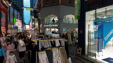 SEOUL, GÜNEY KOREA - 11 Ekim 2025 - İnsanlar Seul 'de işlek bir cadde boyunca alışveriş yapıp yürüyorlar.