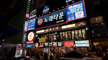 BUSAN, Güney Kore - 10 EKİM 2025 - Busan 'da Korece yazılar bulunan kalabalık bir sokak binasının gece görüşü