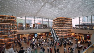 SEOUL, GÜNEY KORE - 11 Ekimde. 2025 - Modern bir alışveriş merkezinde insanların kitap okuduğu bir halk kütüphanesi
