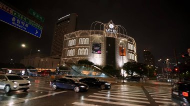 SEOUL, GÜNEY KORE - 11 Ekimde. 2025 - Jamsil 'deki Lotte Mağazası gece sokak trafiği ve ıslak yollarla aydınlatıldı