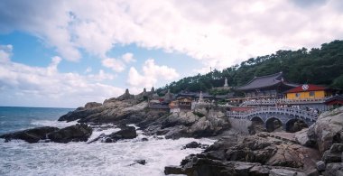BUSAN, GÜNEY KORE 10 EKİM. 2025 - Okyanus dalgaları ve insanlarla dolu Busan 'ın kayalık kıyı şeridinde Haedong Yonggungsa Tapınağı