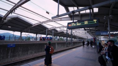ULSAN, GÜNEY KORE - 10 EKİM. 2025 - Seul 'e giden bir KTX hızlı treni için bir tren platformunda bekleyen gezginler