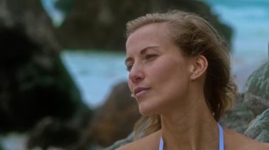 Kendine güvenen bir kadının büyüleyici bir portresi. Saçları dağınık ve doğada kararlı bir ifade.