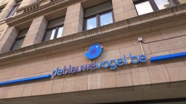 BRÜKSEL, BELGIUM - 26 Kasım 2025 - De Blauwe Vogel seyahat acentası logosu Brüksel Belçika 'da inşa cephesi üzerine