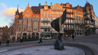 BRÜKSEL, BELGIUM - 26 Kasım 2025 - Günbatımında modern heykel ve tarihi binalar ile Brüksel şehir caddesi