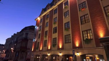 BRÜKSEL, BELGIUM - 26 Kasım 2025 - Warwick Brüksel otel cephesi alacakaranlıkta şehir caddesini aydınlatıyor
