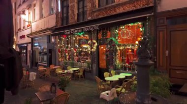 BRÜKSEL, BELGIUM - 26 Kasım 2025 - Geceleri Chez Charles brasserie, Noel ışıkları ve açık hava oturma düzeniyle süslenmiş