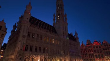 BRÜKSEL, BELGIUM - 26 Kasım 2025 - Brüksel Belediyesi, belirgin Gotik şehir simgesi, gece mavi gökyüzünün altında aydınlandı