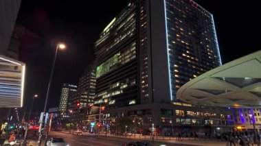 BRÜKSEL, BELGIUM - 26 Kasım 2025 - Günbatımından sonra modern mimari ve parlak ışıklarla Brüksel şehir sokağı