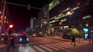 BRÜKSEL, BELGIUM - 26 Kasım 2025 - Brüksel 'de geceleyin trafik, yayalar ve aydınlanmış modern binaların olduğu şehir caddesi