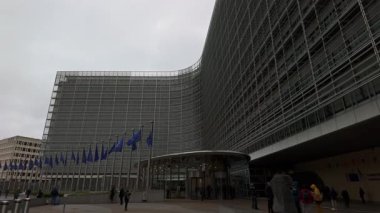 BRÜKSEL, BELGIUM - 26 Kasım 2025 - Berlaymont Avrupa Birliği bayrakları ile ön cephe bulutlu bir gökyüzü altında