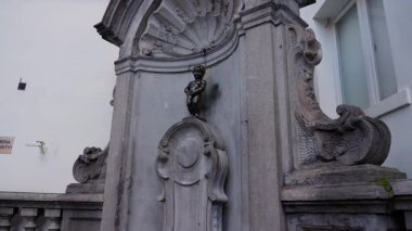 BRÜKSEL, BELGIUM - 26 Kasım 2025 - Brüksel, Belçika 'da bir taş çeşmenin üzerine işeyen çocuğun ikonik bronz heykeli